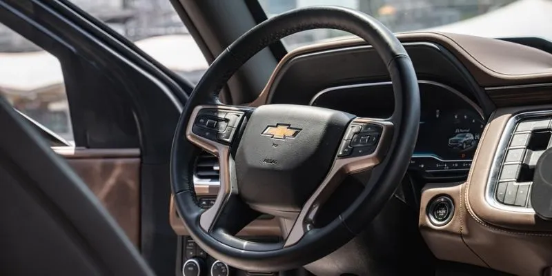 Interior view of Chevrolet Suburban luxury driver cockpit featuring leather-wrapped steering wheel and dashboard