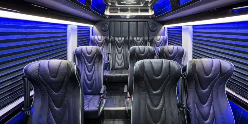 Luxury interior cabin of a Mercedes Sprinter van featuring custom black leather seats and LED ambient lighting